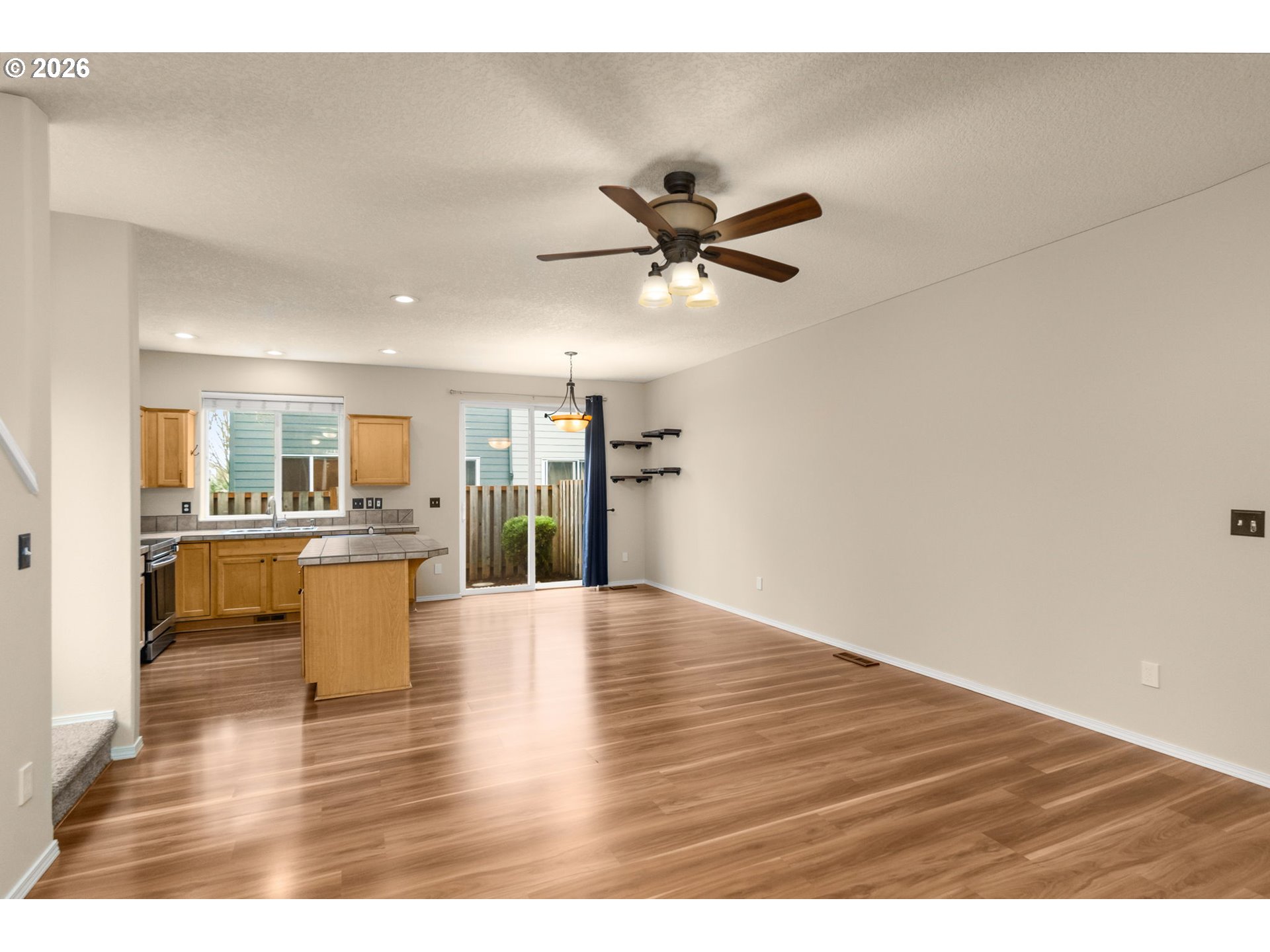 17428 Southwest September Lane Beaverton, OR 97003 - Photo 3 of 23 a view of an empty room and kitchen with wooden floor