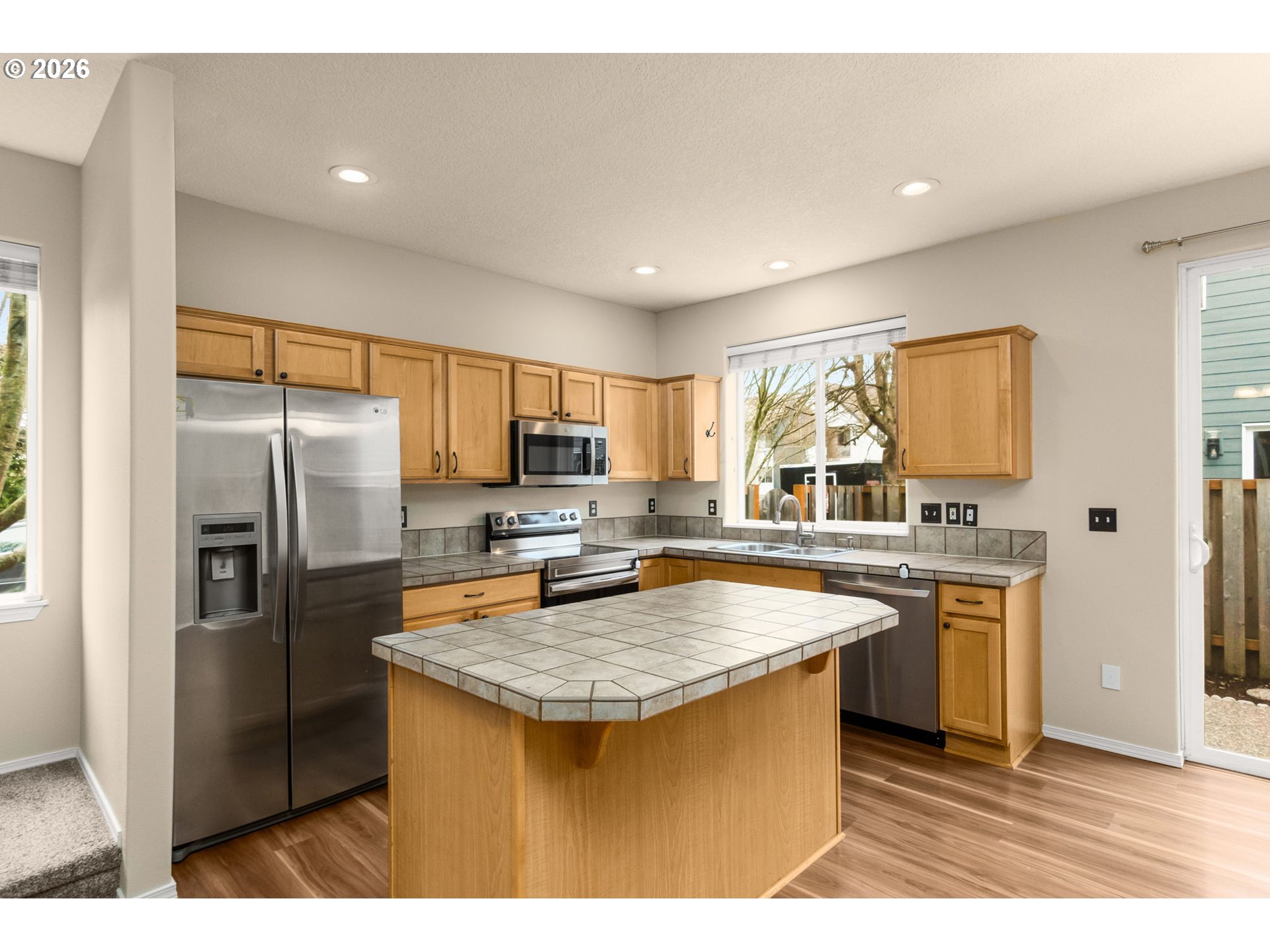 17428 Southwest September Lane Beaverton, OR 97003 - Photo 7 of 23 a kitchen with stainless steel appliances granite countertop a kitchen island a stove a refrigerator a sink a counter space and cabinets