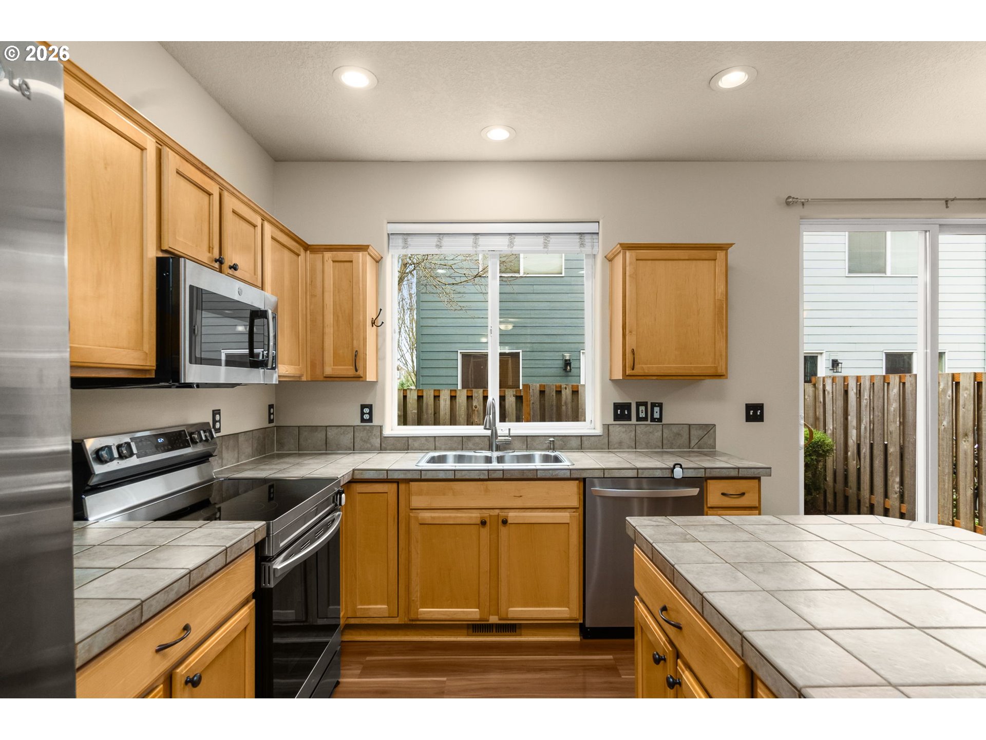 17428 Southwest September Lane Beaverton, OR 97003 - Photo 8 of 23 a kitchen with a stove a sink a microwave a counter space and cabinets