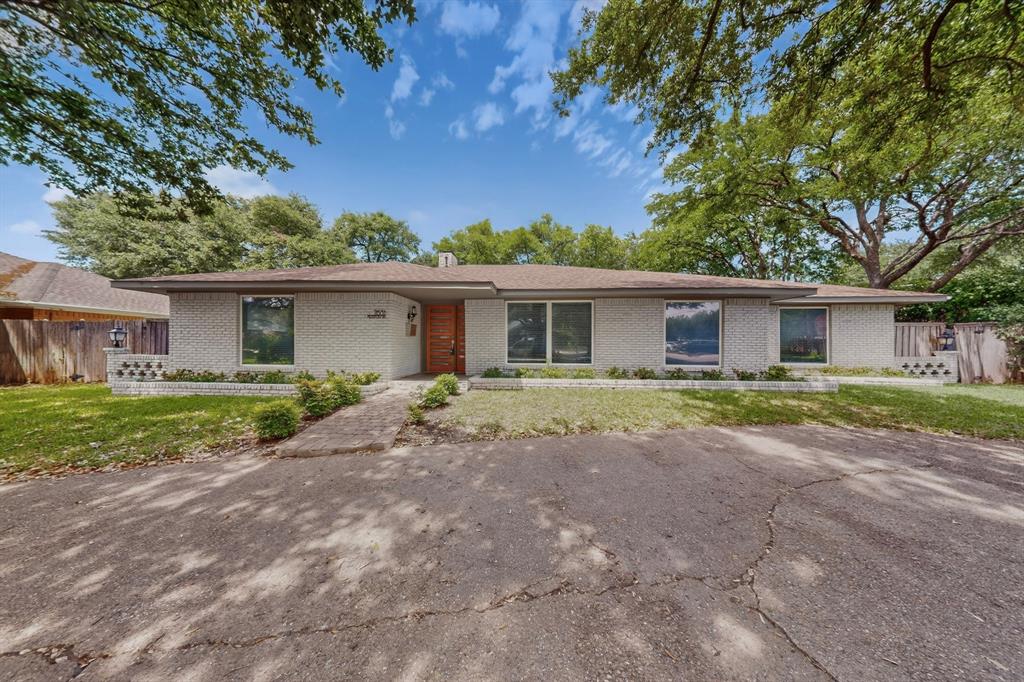 7631 Meadow Road Dallas, TX 75230 - Photo 39 of 40 A cozy house with a driveway surrounded by trees
