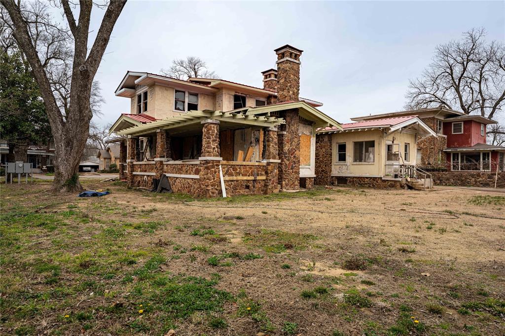 621 South Main Street Paris, TX 75460 - Photo 17 of 30 Back of house with metal roof, stone siding, and a chimney
