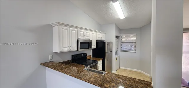 a kitchen with stainless steel appliances granite countertop a sink stove and microwave