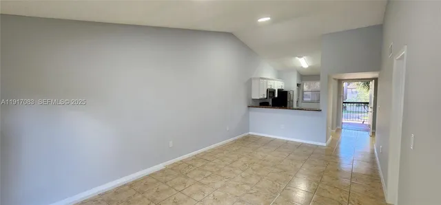 a view of a hallway with kitchen space and a window