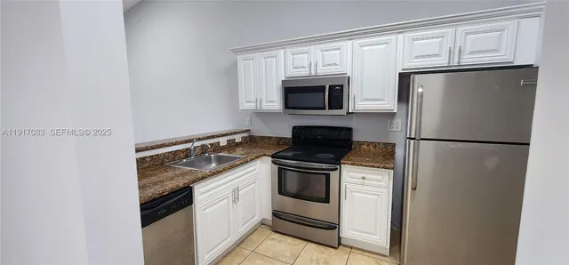 a kitchen with stainless steel appliances granite countertop a stove microwave and refrigerator
