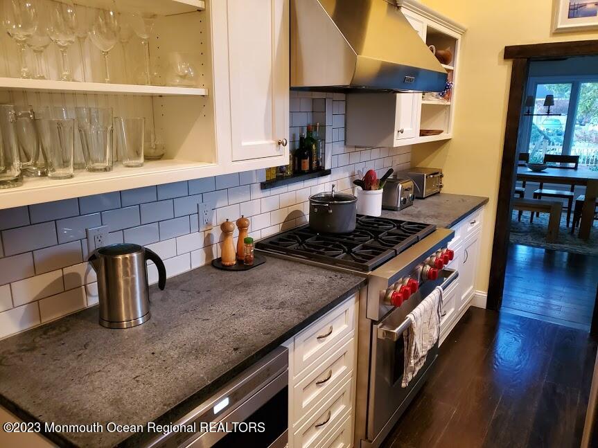 218 Bridge Avenue Point Pleasant Beach, NJ 08742 - Photo 5 of 19 a kitchen with stainless steel appliances granite countertop a sink a stove and a wooden cabinets