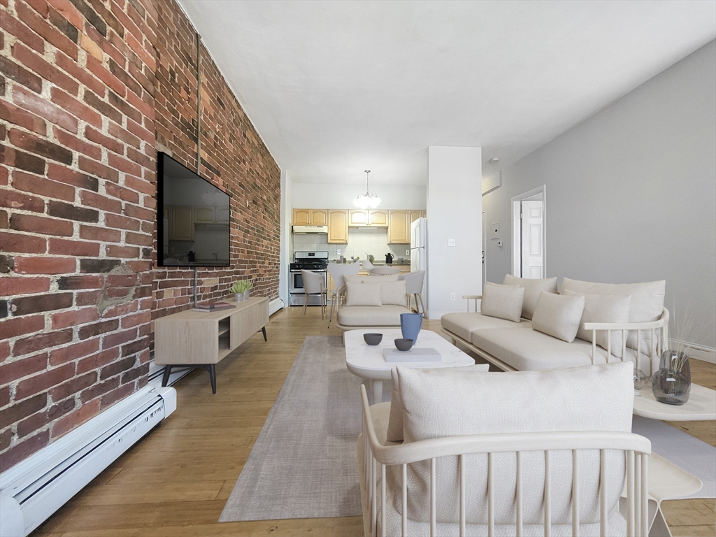 338-342 Warren Street, Unit 1 Boston, MA 02119 - Photo 2 of 10 a living room with furniture and a flat screen tv