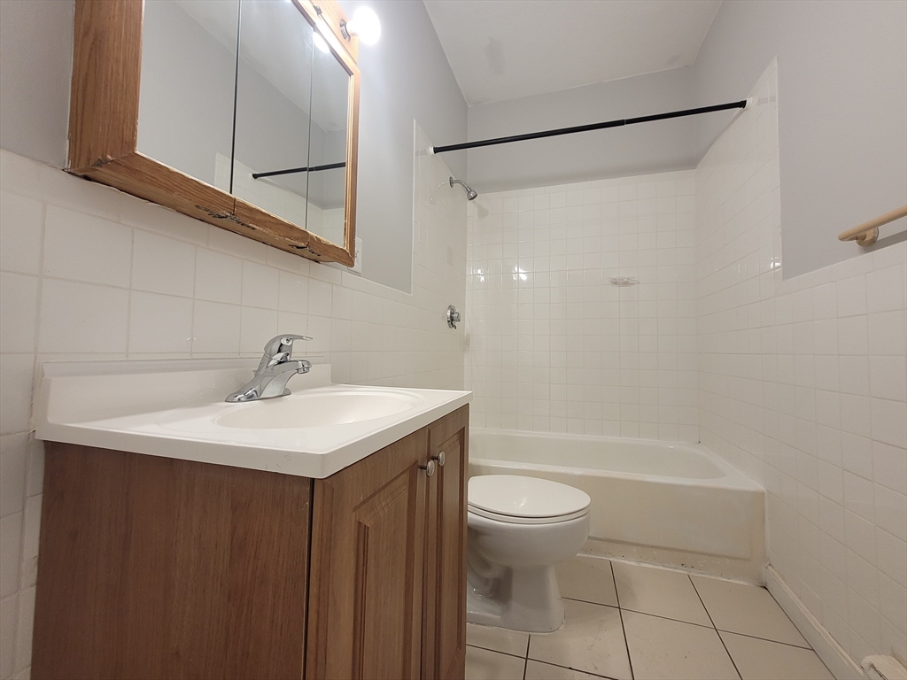 338-342 Warren Street, Unit 1 Boston, MA 02119 - Photo 10 of 10 a bathroom with a sink a toilet and shower
