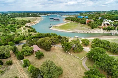 an aerial view of residential houses with outdoor space and lake view