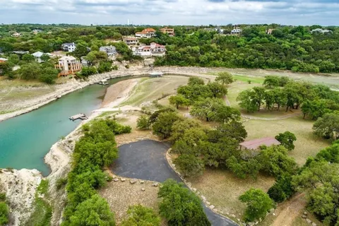 an aerial view of residential houses with outdoor space and lake view