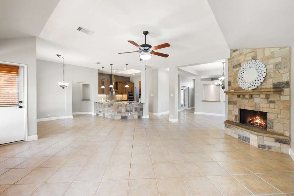 604 Cutty Trail Lakeway, TX 78734 - Photo 5 of 40 a view of a livingroom with a fireplace a chandelier and windows