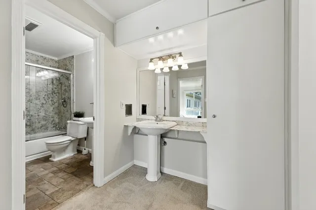 a bathroom with a sink a toilet and a mirror