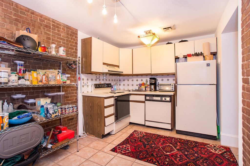 280 Commonwealth Avenue, Unit G9 Boston, MA 02116 - Photo 10 of 18 a kitchen with refrigerator and cabinets