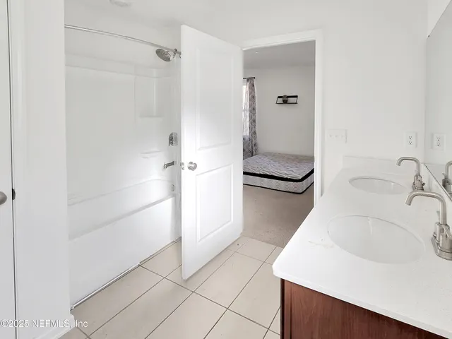 a bathroom with a granite countertop sink and a shower