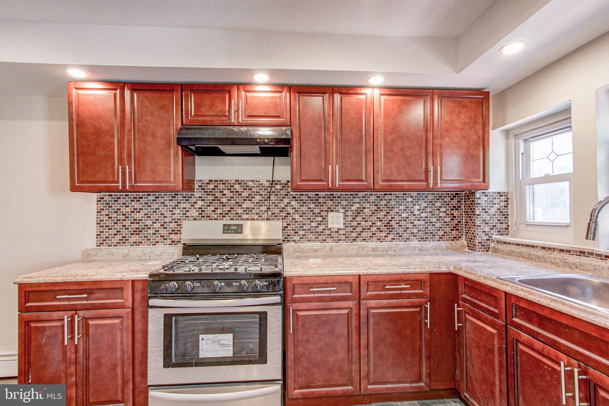 524 Glendale Road Upper Darby, PA 19082 - Photo 23 of 51 a kitchen with granite countertop cabinets stainless steel appliances a sink and wooden floor
