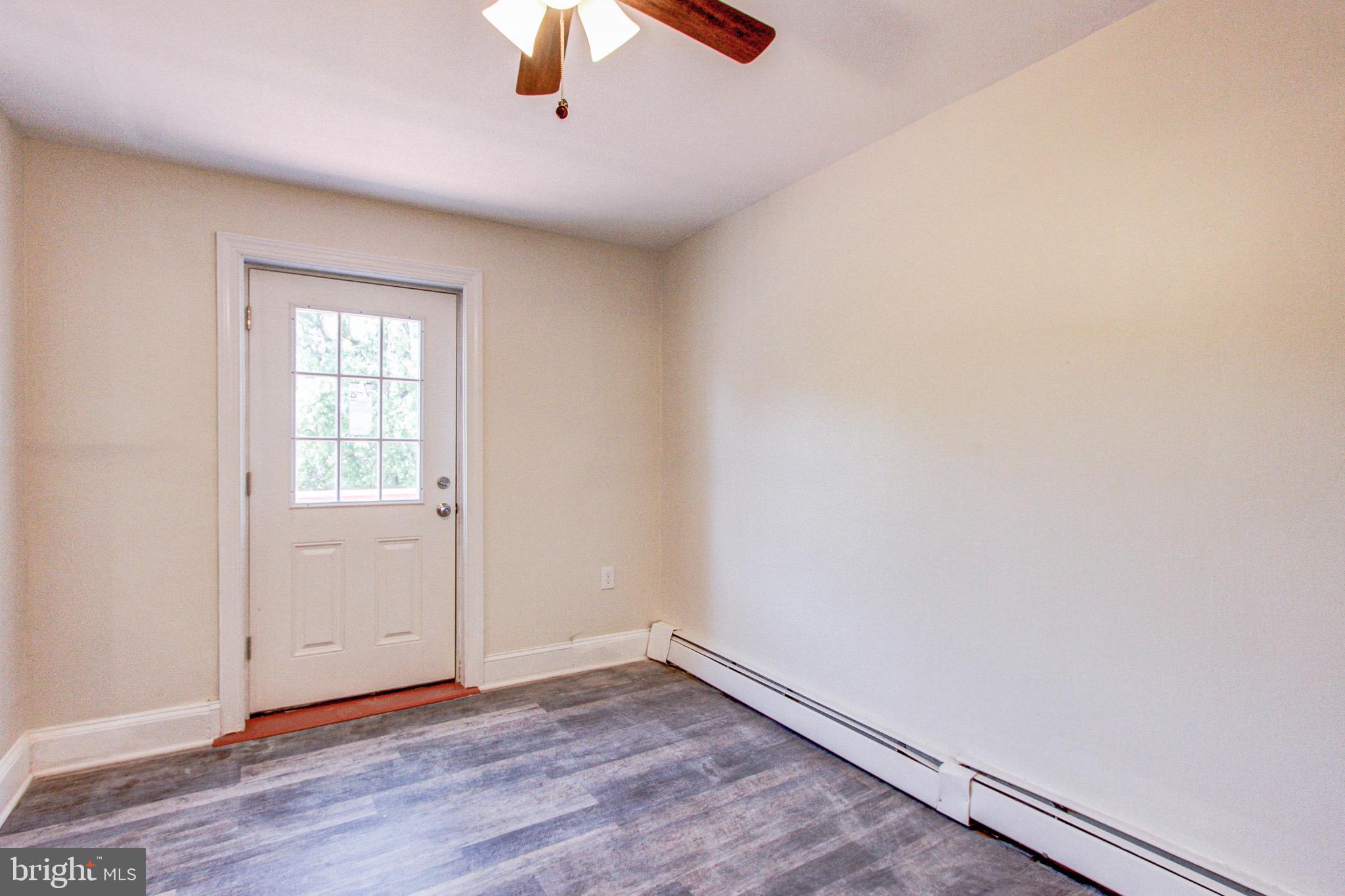 524 Glendale Road Upper Darby, PA 19082 - Photo 40 of 51 an empty room with wooden floor chandelier fan and windows