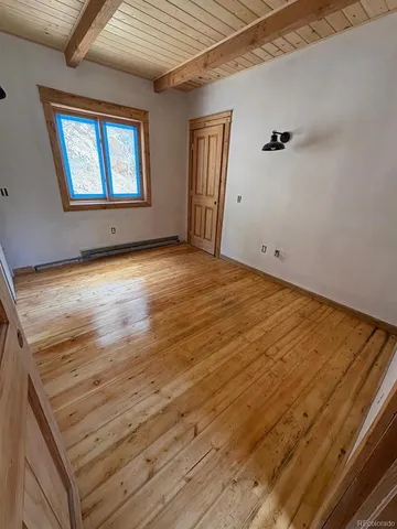 a view of empty room with wooden floor