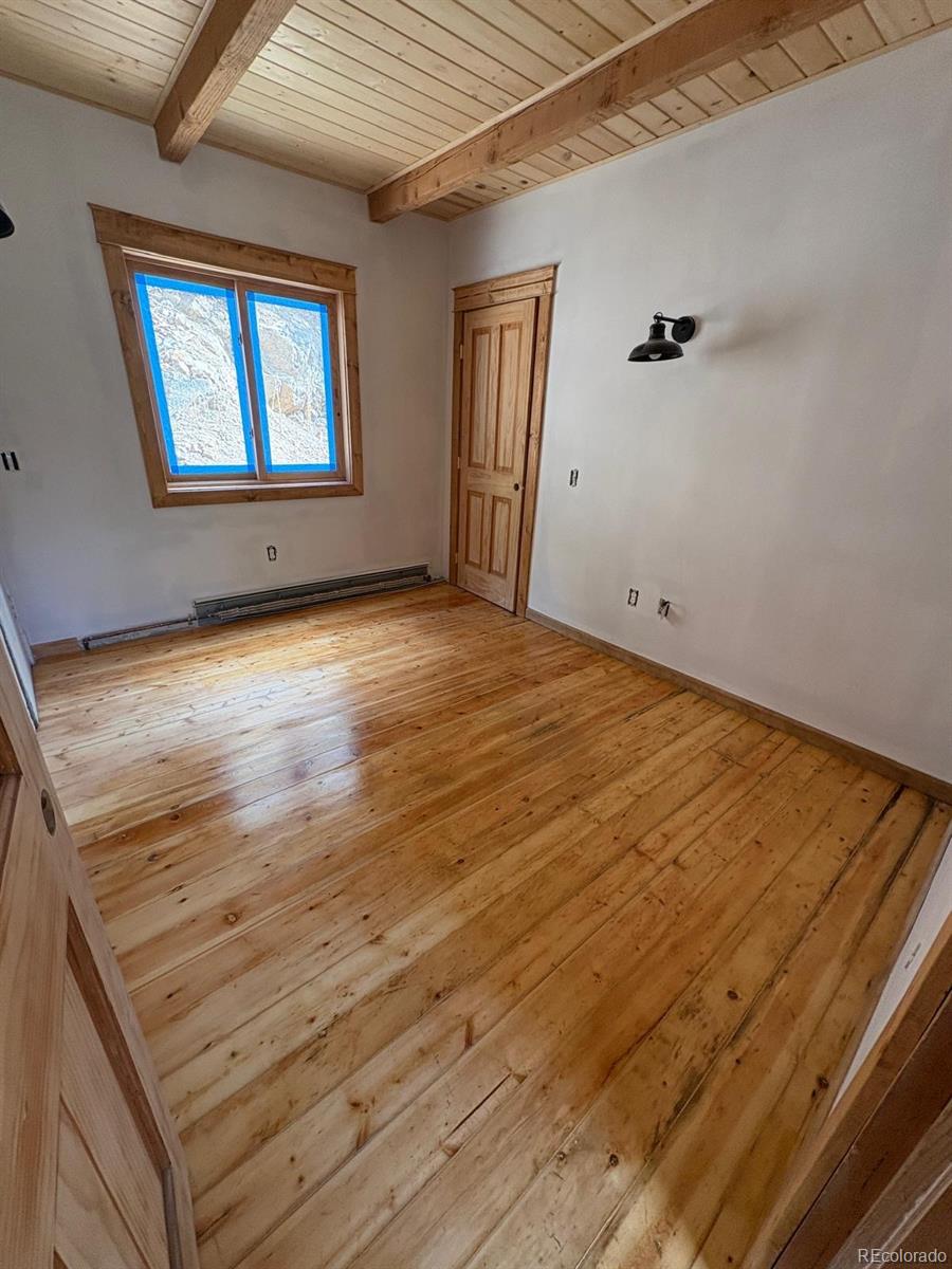 397 Glendale Gulch Road Boulder, CO 80302 - Photo 13 of 17 an empty room with wooden floor and windows