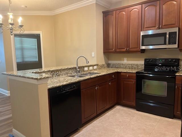 200 Riverview Bend South, Unit 911 Palm Coast, FL 32137 - Photo 8 of 23 a kitchen with stainless steel appliances granite countertop a stove a sink and a microwave