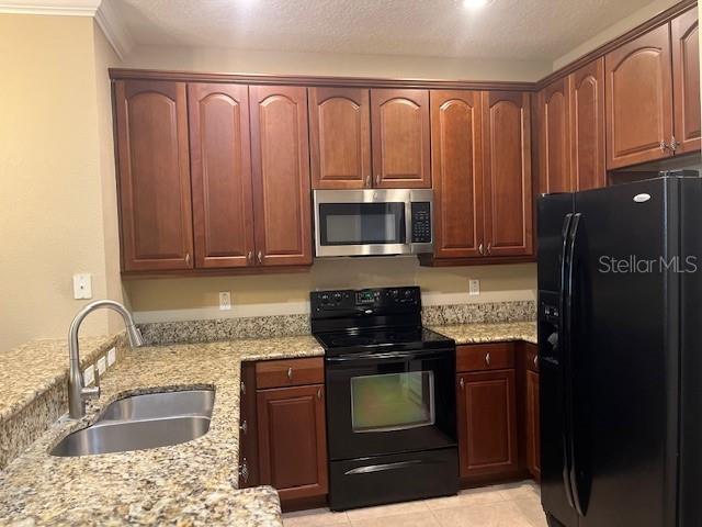 200 Riverview Bend South, Unit 911 Palm Coast, FL 32137 - Photo 9 of 23 a kitchen with granite countertop a stove top oven microwave and cabinets