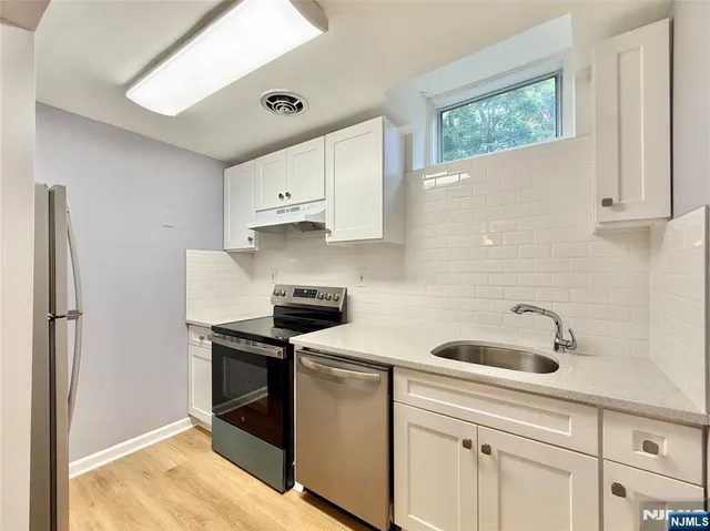 a kitchen with a sink cabinets and stainless steel appliances