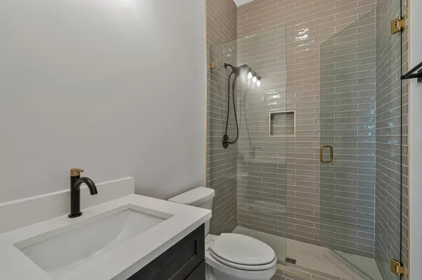 a bathroom with a sink a toilet and shower