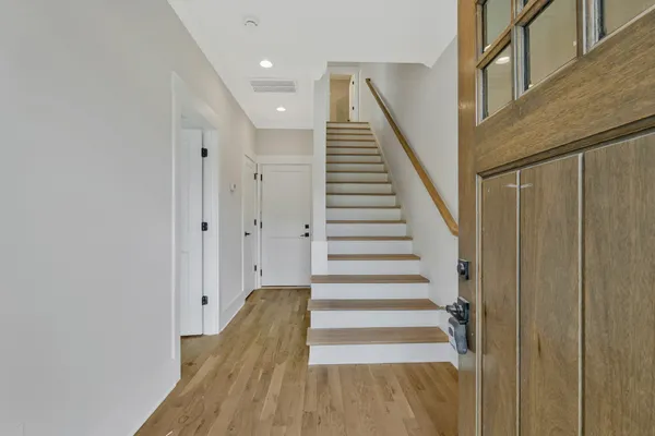 a view of a hallway with wooden floor and entryway