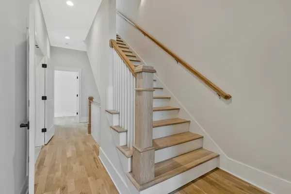 a view of a hallway with wooden floor and staircase