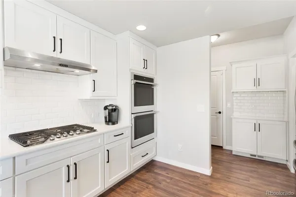 a kitchen with stainless steel appliances white cabinets and stove