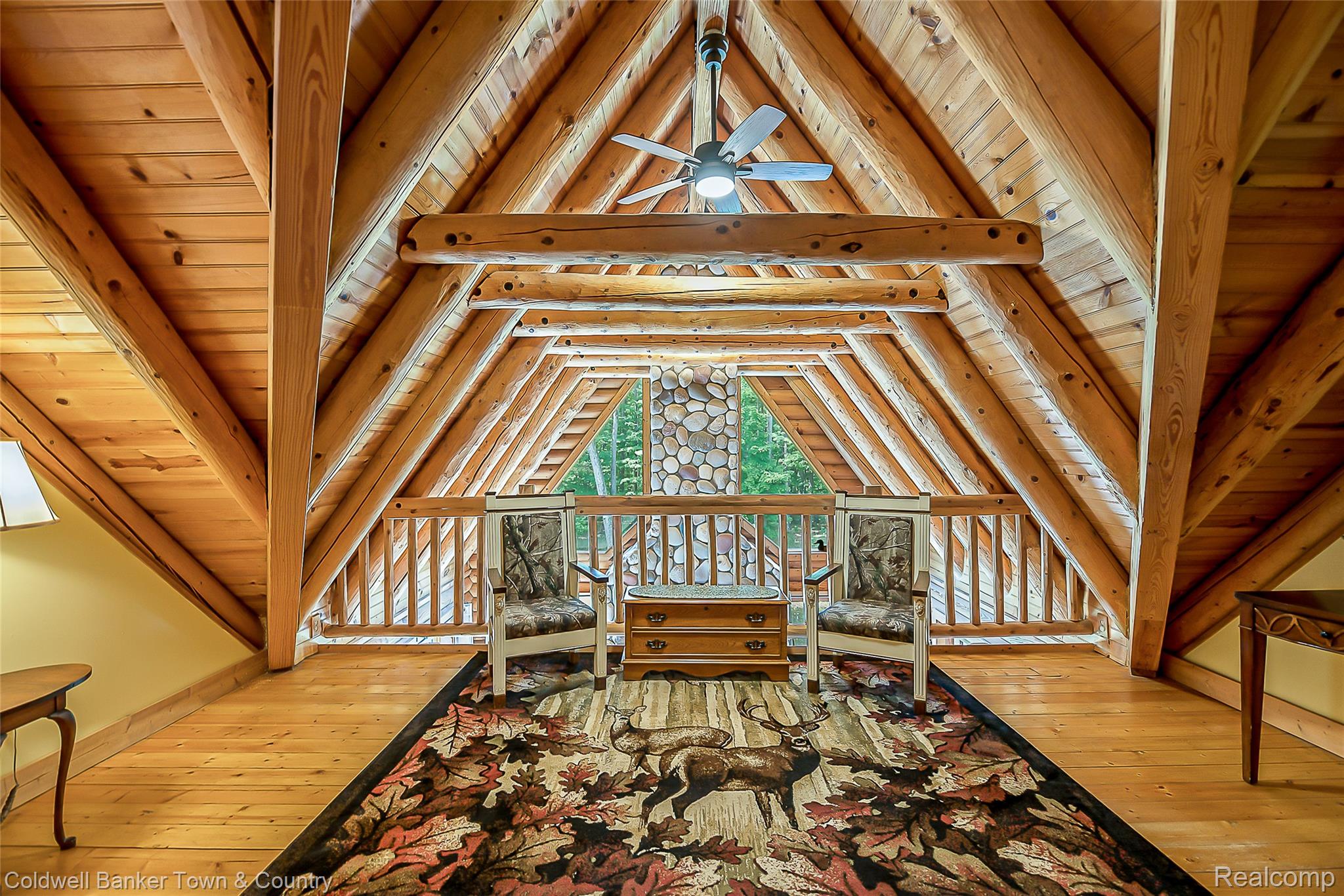 7023 Munsell Road Howell, MI 48843 - Photo 43 of 55 Vaulted wood-paneled ceiling with exposed log beams, wood-finish flooring, a ceiling fan, and a stone-clad architectural feature