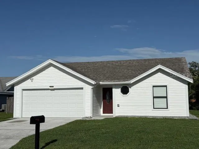 a front view of a house with a yard and garage