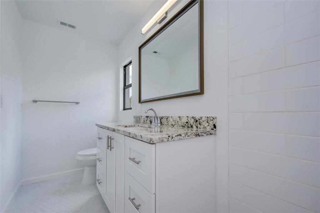 3540 65th Ave Circle East Sarasota, FL 34243 - Photo 11 of 69 a bathroom with a granite countertop toilet sink and mirror
