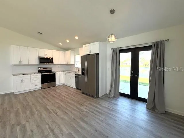 a kitchen with a refrigerator and a stove top oven