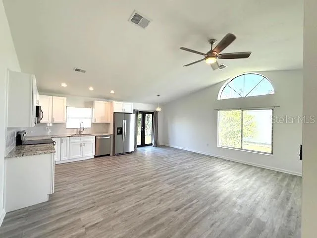 a view of a kitchen with a sink wooden floor and a window