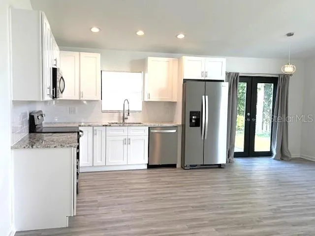 a kitchen with stainless steel appliances granite countertop a refrigerator and a stove top oven
