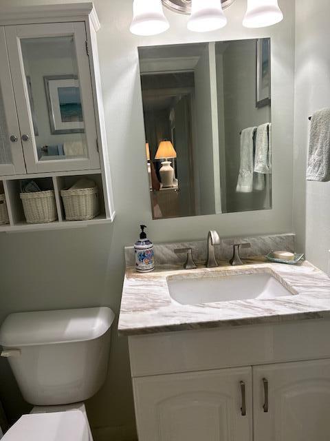 1955 Southwest Palm City Road, Unit H Stuart, FL 34994 - Photo 15 of 22 a bathroom with a toilet sink and mirror