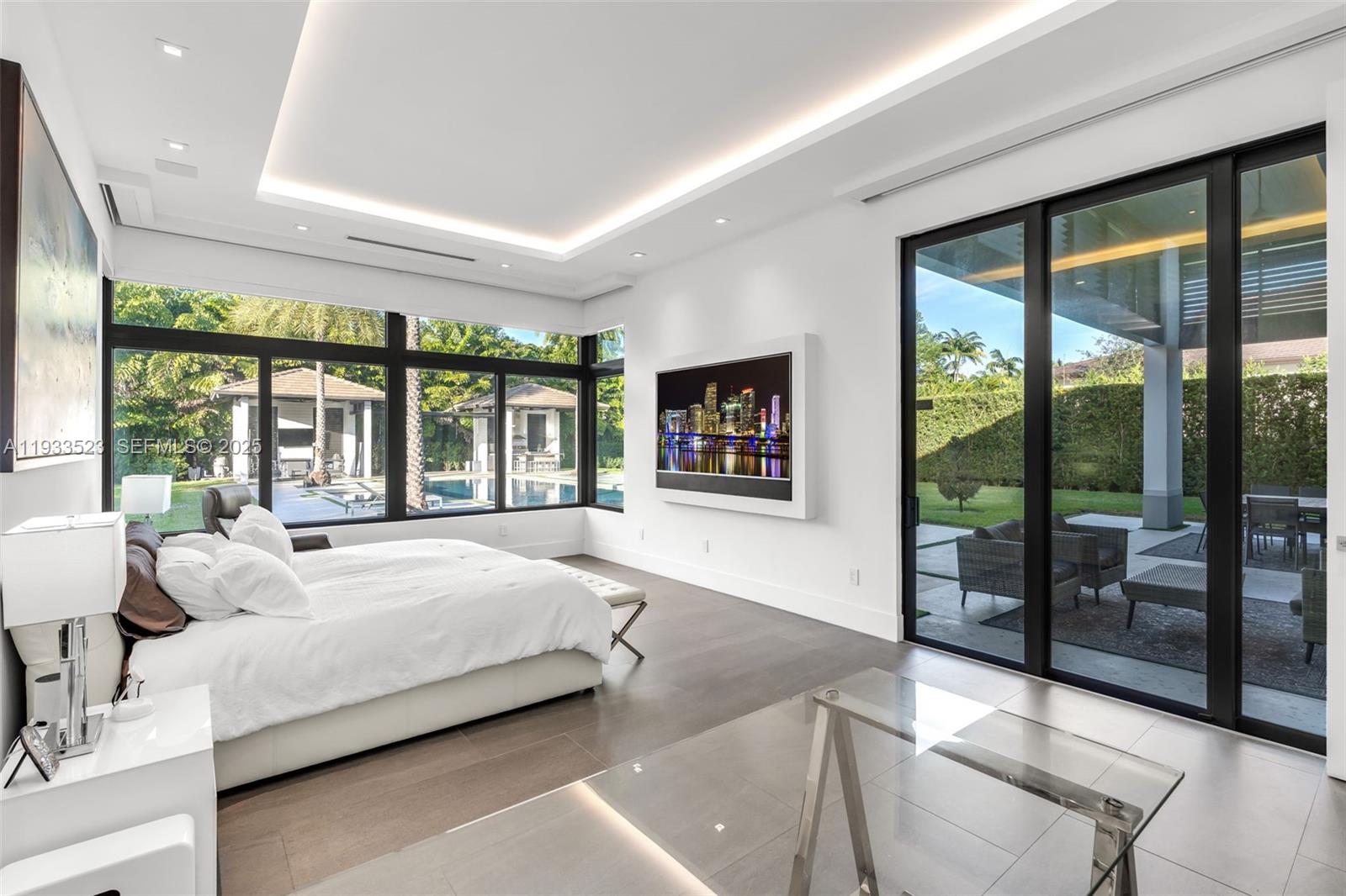 8271 Southwest 67th Street Miami, FL 33143 - Photo 48 of 88 a spacious bedroom with a large bed and a large window