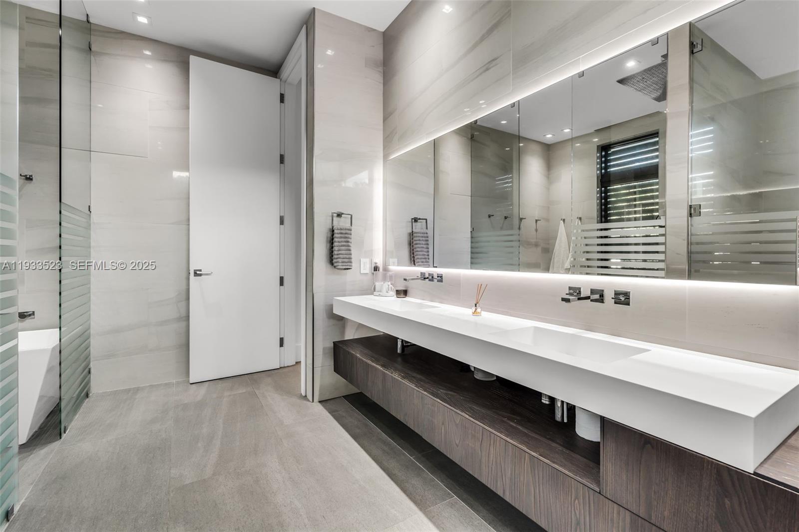 8271 Southwest 67th Street Miami, FL 33143 - Photo 56 of 88 a bathroom with a double vanity sink a toilet and shower