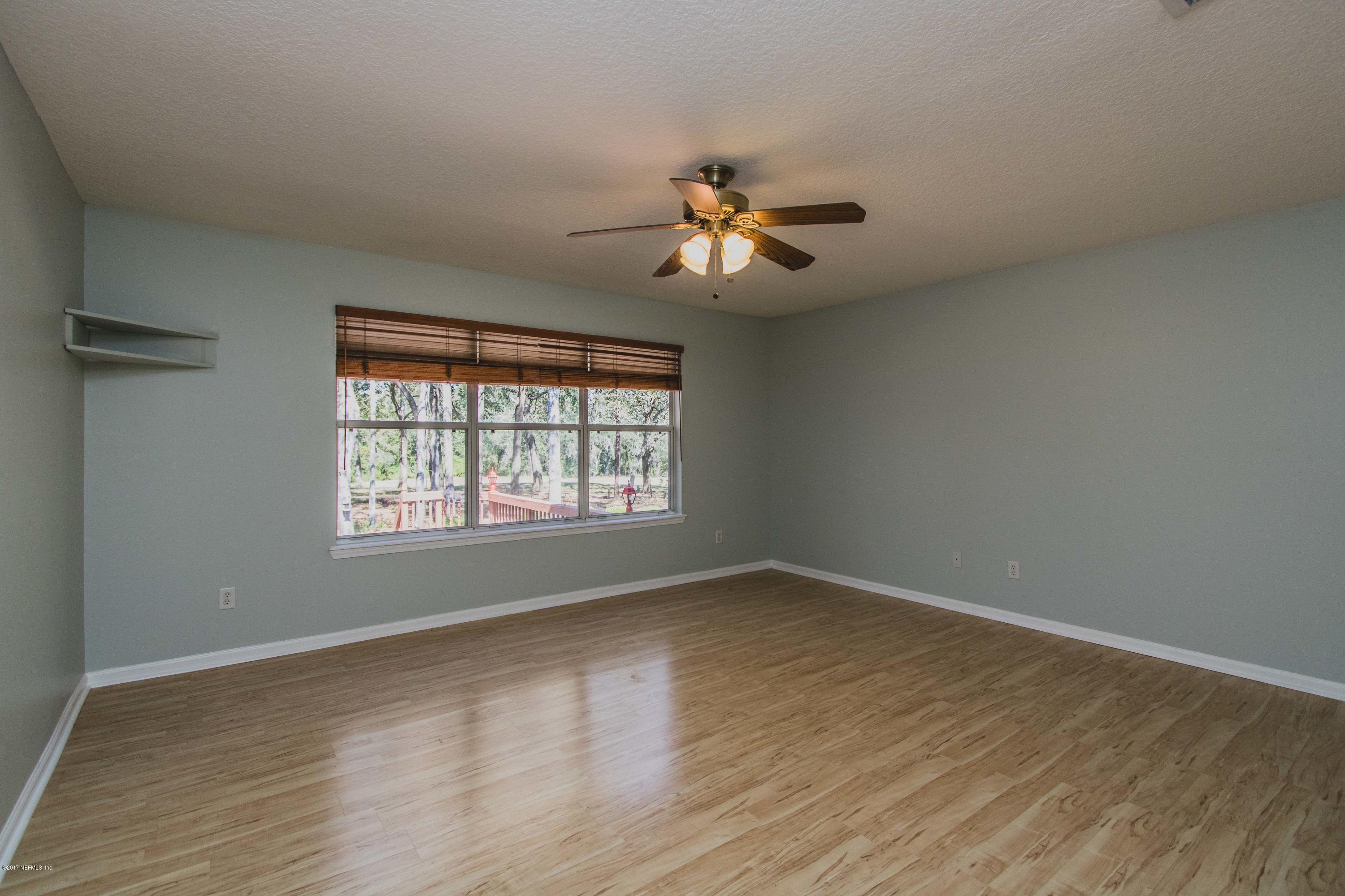 3123 Ravines Road Middleburg, FL 32068 - Photo 12 of 32 a view of empty room with wooden floor and fan