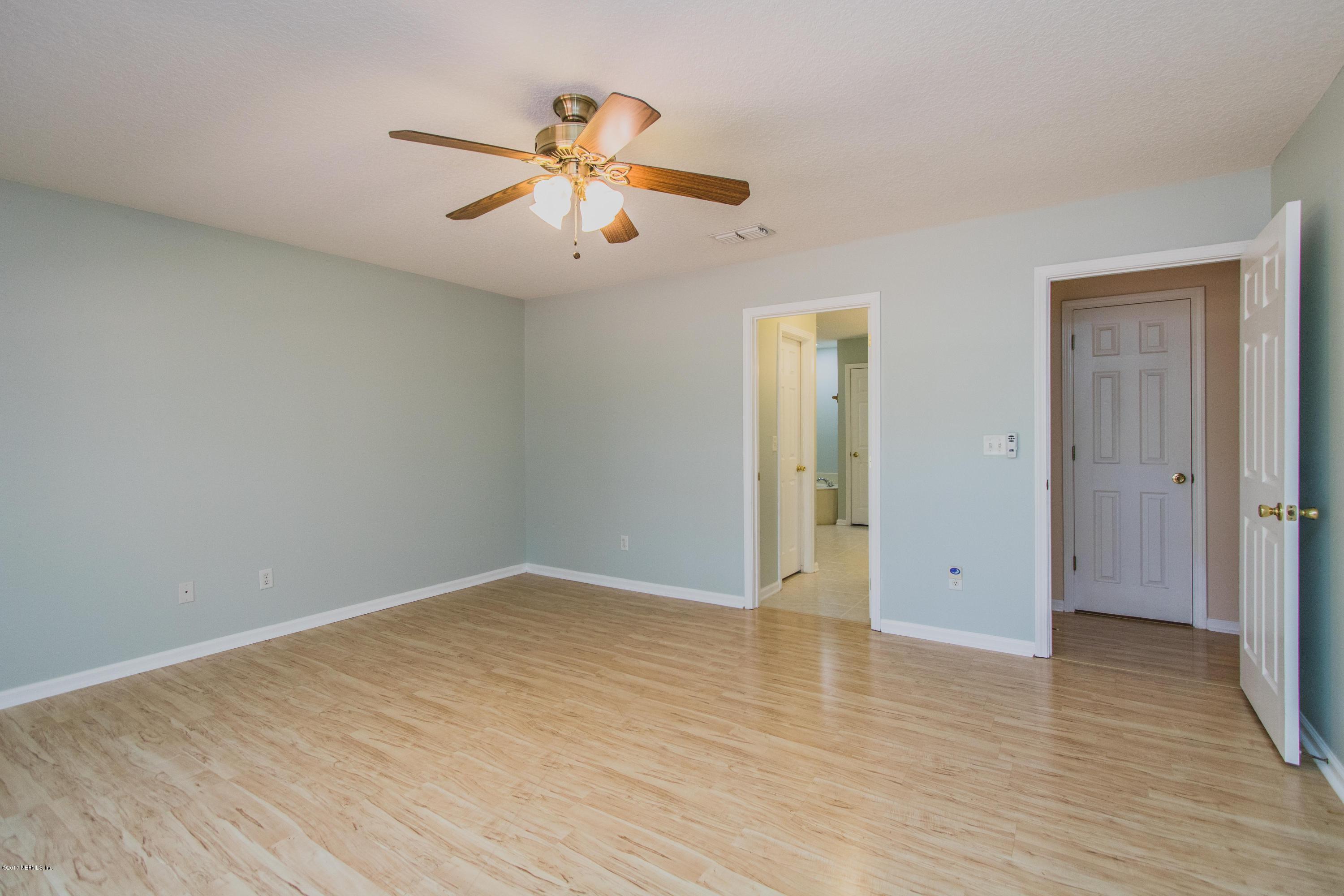3123 Ravines Road Middleburg, FL 32068 - Photo 13 of 32 an empty room with wooden floor and windows