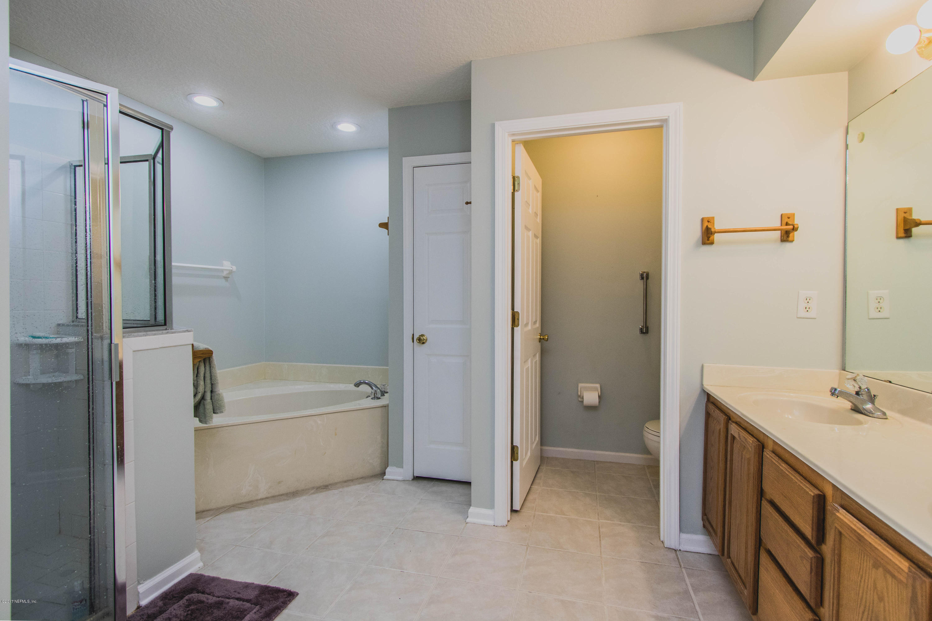 3123 Ravines Road Middleburg, FL 32068 - Photo 14 of 32 a bathroom with a tub a sink and a large mirror
