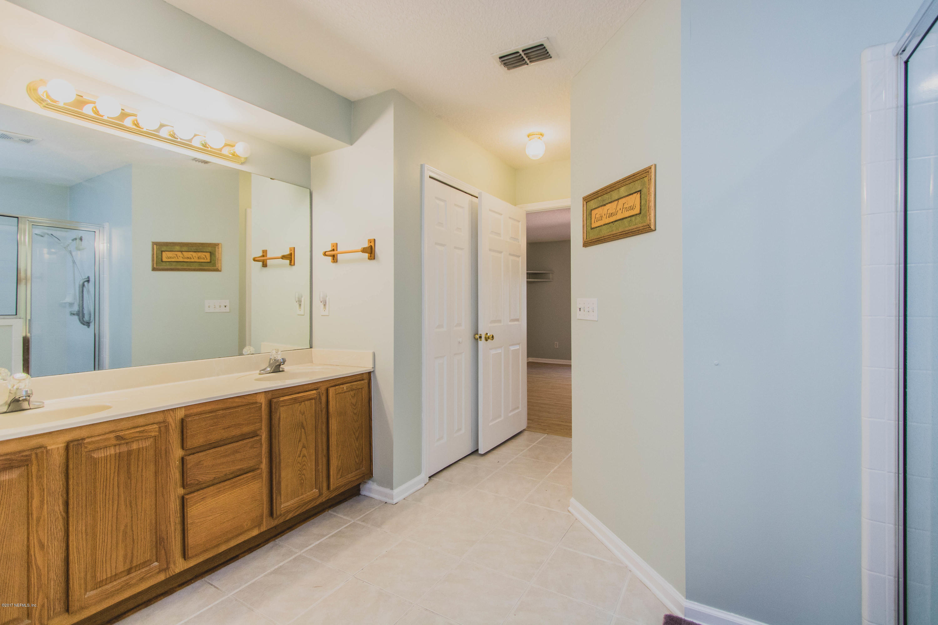 3123 Ravines Road Middleburg, FL 32068 - Photo 15 of 32 a spacious bathroom with a double vanity sink a mirror and a shower