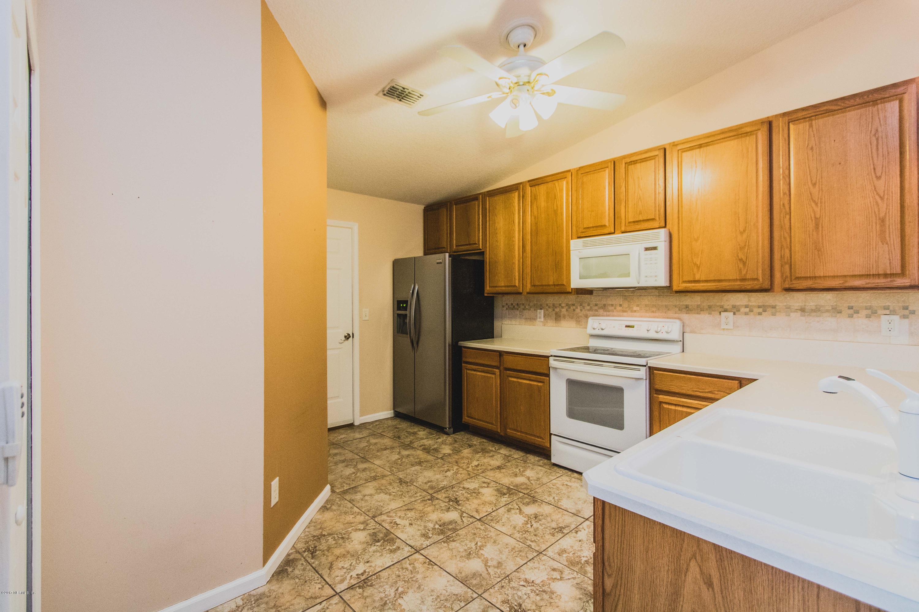 3123 Ravines Road Middleburg, FL 32068 - Photo 9 of 32 a kitchen with stainless steel appliances granite countertop a stove a sink and a refrigerator