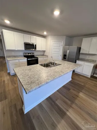 a kitchen with granite countertop a stove and a wooden floors