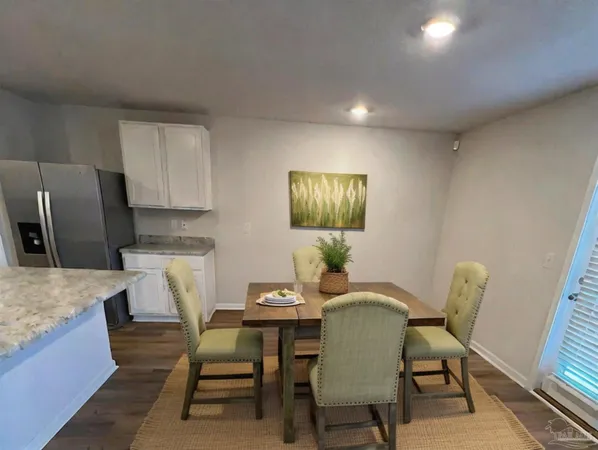 a view of a dining room with furniture and a refrigerator