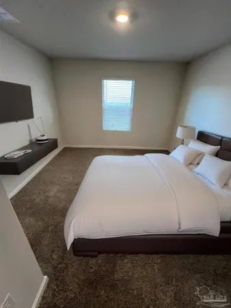 a bedroom with a bed and a flat screen tv