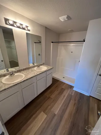 a spacious bathroom with a double vanity sink and mirror