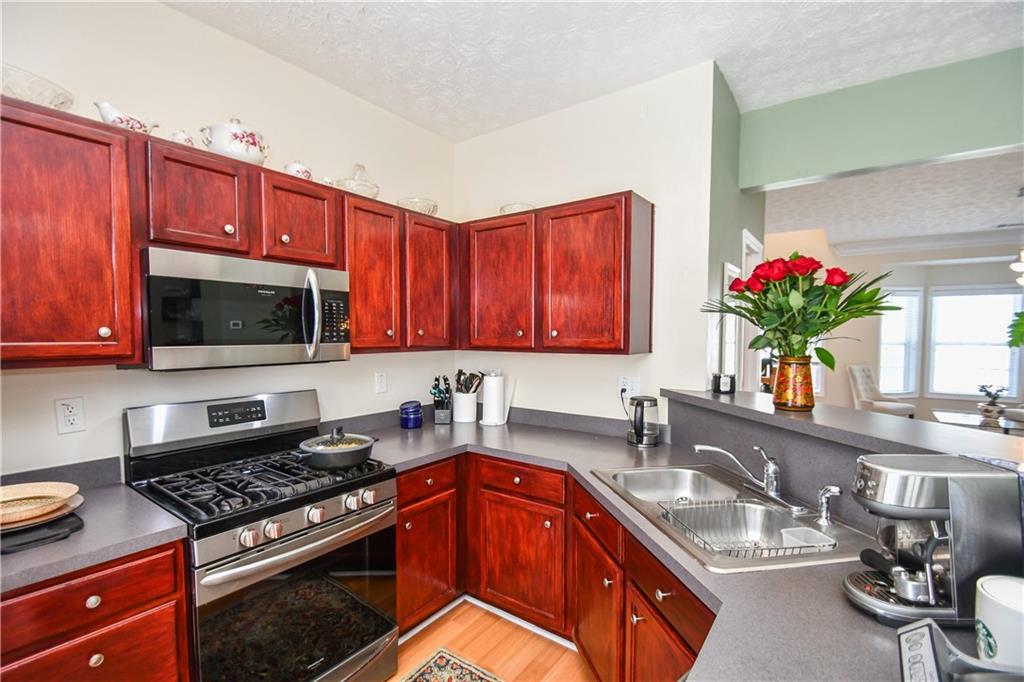 1609 Indian Way Cumming, GA 30040 - Photo 21 of 72 a kitchen with stainless steel appliances granite countertop a sink stove and microwave