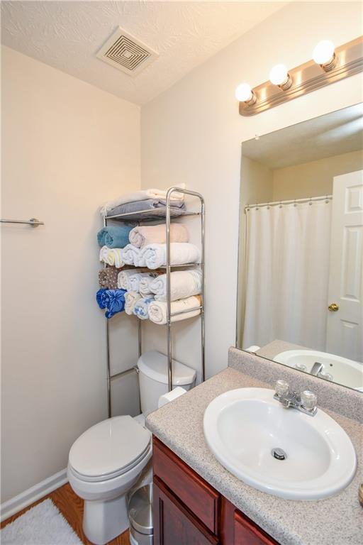 1609 Indian Way Cumming, GA 30040 - Photo 49 of 72 a bathroom with a sink a toilet and mirror