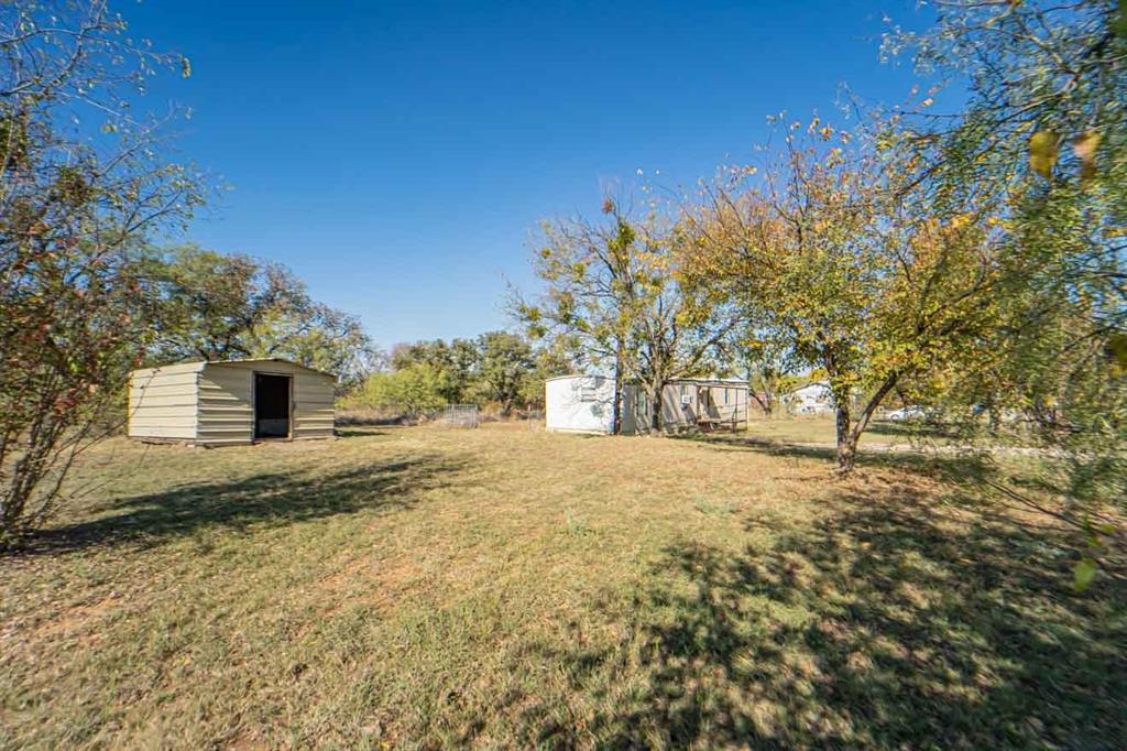 516 South Butte Street Breckenridge, TX 76424 - Photo 15 of 17 a yellow house with trees in front of it