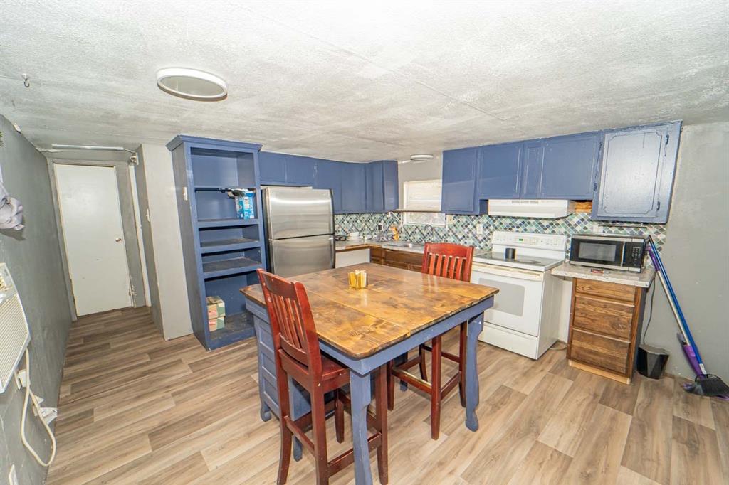 516 South Butte Street Breckenridge, TX 76424 - Photo 10 of 17 a kitchen with refrigerator cabinets and wooden floor